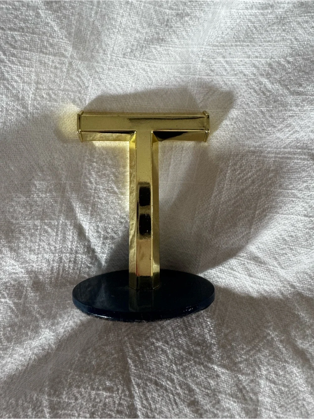 Umbra Gold T-Shaped Jewelry Stand on Navy Base